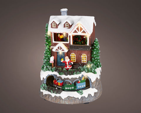 Weihnachtliche led szene kleiner zug mit warmweißen led lampen hausfigur mit rotem santa schnee und zug unter dem dach