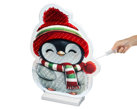 Ein festlicher led infinity pinguin cutout mit rot-grün gestreiftem strickmütze und passendem schal