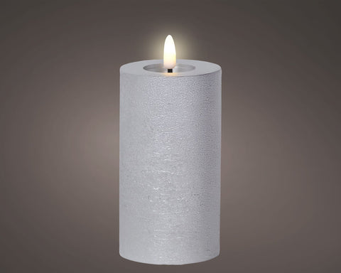 Eine weiße texturierte zylindrische led kerze aus wachs mit leuchtender flamme für dauerbetrieb indoor
