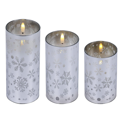 Set aus drei silbernen led-kerzenhaltern mit schneeflockenmuster und mattiertem glas für stimmungsvolles licht