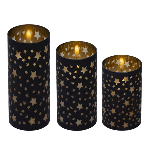Set aus drei schwarzen kerzenhaltern mit goldenen sternausschnitten und leuchtenden led-kerzen im 3er set