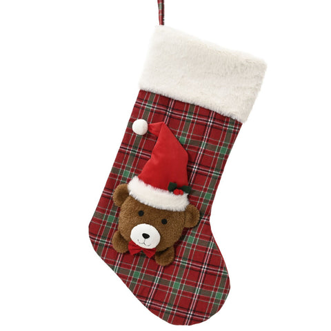 Rote und grüne karierte polyester strumpf mit braunem kuschelteddy im roten weihnachtshut