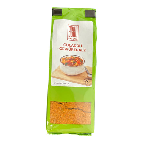 Grüne beutel gulasch gewürzsalz mit durchsichtigem fenster und orangebraunen granulaten im produkt gulasch gewürzsalz