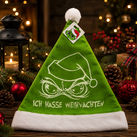 Grüne samt santamütze mit weißem fellbesatz und stilisiertem grinch gesicht plus ich hasse weihnachten stickerei