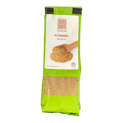 Hellgrüne verpackung des öko lebensmittelbrands mit gemahlenem kümmel für würzen und kochen