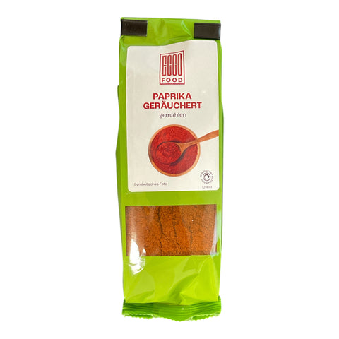 Vibrant grün-gelbe packung paprika geräuchert 60g mit durchsichtigem fenster zeigt rote pulverfüllung