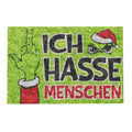 Grüne fußmatte aus textil mit cartoon grinch im santa-hut und ich hasse menschen schriftzug plus zeigefingerillustration