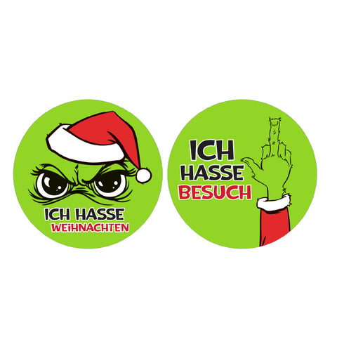 Zwei grüne runde aufkleber mit grinch in weihnachtsmütze und hand zeigt mittelfinger für plüschkissen festtagsmuffel 30cm