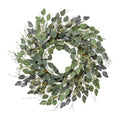 Ein runder eukalyptus-mix-kranz mit grün-grauen blättern, weißen blüten und dünnen braunen zweigen