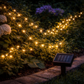 Warme mikro-solarlichterkette mit 100 goldenen led-lichtern und schwarzem solarbetrieb für außen an grünem laub