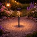 Schwarzer metall solar-gartenstecker mit filigranem floralen ausschnitt und warmweißem led-lichtschein
