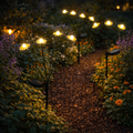 Solar-blumenstecker in schwarz mit solarbetrieb und warmweißen gelben leuchtpunkten in form von gänseblümchen