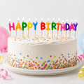 Runde weiße geburtstagstorte mit bunten buchstabekerzen happy birthday und regenbogensprinkles dekoriert
