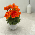 Eine lebhafte orange künstliche ranunkelblumen im eleganten weißen keramiktopf ranunkel orange