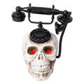 Schwarzes rotary telefon auf weißem schädel mit leuchtend roten augen totenkopftelefon animiert 22x25 cm