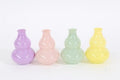 Vier pastellfarbene keramikvasen in kürbisform in lavendel, rosa, mintgrün und gelb, vase