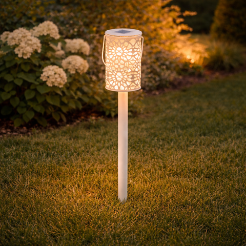 Weiße laternenförmige solar gartenleuchte lumineo mit filigranen ausschnitten und griff aus beigem metall