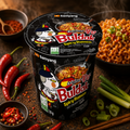 Schwarzer samyang buldak scharfer ramen becher mit rotem und gelbem branding und cartoon charakterdesign