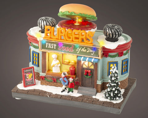 Ein festlicher miniature burgerladen mit warmweißer led beleuchtung, hellblau rotem fachwerk und schneebedecktem dach
