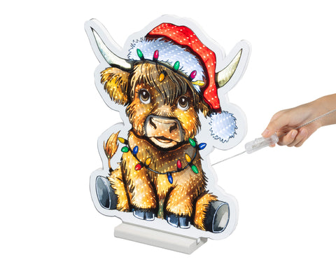 Ein festlicher led infinity büffel aus holz mit roter weihnachtsmütze und bunten lichterketten am hals