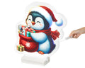 Ein festlicher led infinity pinguin aus warmweißen leds trägt eine santa mütze und hält einen geschenkesack