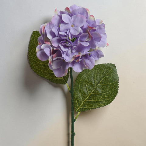 Eine zarte künstliche hortensie aus polyester mit lavendelfarbenen blüten und grünen blättern an schlankem stiel