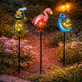 Drei bunte solar-gartenstecker in tiermuster design als frosch flamingo und raupe aus kunststoff