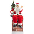 Rote und weiße plüsch-santa-figur auf einem steinernen kamin sitzend mit mini-weihnachtsbaum und laterne