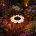 Ein solar blume 12led 15cm warmweiß/weiß gartenlicht mit schwarzem solarpanel zur wegebeleuchtung zwischen blumen