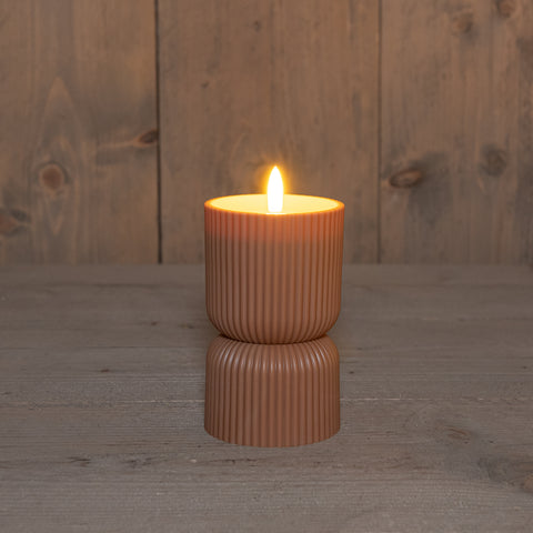 Eine warme bernsteinfarbene outdoor-kerze 3d docht 8x8x15cm terra mit vertikalen rillen auf dunkler oberfläche