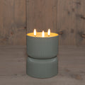 Ein eleganter olivgrüner gerippter keramik kerzenhalter mit drei brennenden kerzen outdoor-kerze 3d docht