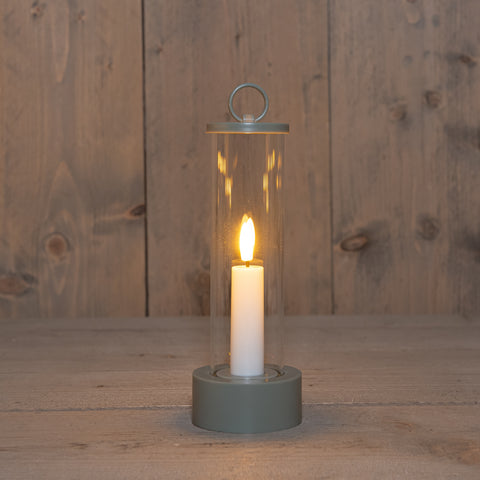 Eine schlanke zylindrische led outdoor kerze im kunststoffglashänger olivegrün mit schwarzem metallring und weißer kerze