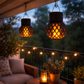 Schwarze solar lampion mit rauten muster und latticedesign hängen von der decke und strahlen warmes orange licht aus