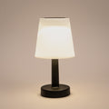 Eine elegante schwarze solar tischlampe mit einem mattweißen, konisch zulaufenden schirm und warmweißer led-beleuchtung