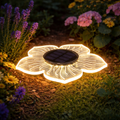 A glowing translucent flower-shaped solar garden light solar blume 12led 15cm warmweiß with black center panel