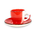 Ein lebendig rotes und weißes keramik espressotasse mit passendem untertasse und feinen horizontalen rillen