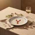 Weißes porzellan-teller hummer mit blau gewelltem rand und roter lobster-illustration in der mitte
