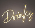 Ein LED-schild neon drinks mit einem warmen goldenen licht in eleganter kursiver schrift