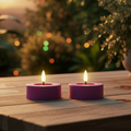 Zwei dunkelrosa led-outdoor-teelichter 6,5x6,5x5 cm mit leuchtender flamme auf holzoberfläche