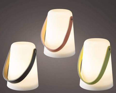 Drei moderne led-laternen outdoor mit zylindrischem körper und bunten ledergriffen in schwarz, braun und grün