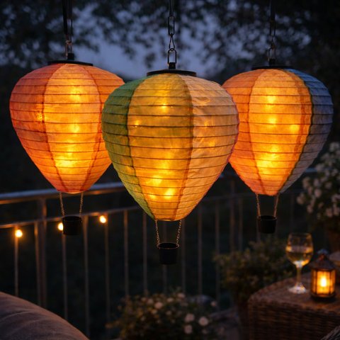 Drei hängende solar led heißluftballon papierlaternen mit warmem flackereffekt in orange, grün-gelb und blau-orange gestreift