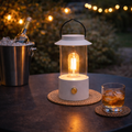 Weiße laterne mit klarglasgehäuse und edison-leuchtmittel, schwarzer griff und goldfarbener basisknopf, warmweiß dimmbar