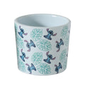 Weißer keramik blumentopf mit blauem stitch muster und hellgrünen tropischen blättern disney bluementopf stitch