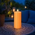 Eine warme orange led-outdoorkerze 7x17,5 cm mit flackerndem flammeneffekt für außenbereiche