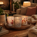 Teelichtglas mit motiv drei dekorative glas-teelichthalter mit orchideen schmetterlingen und geometrischen mustern auf holztablett