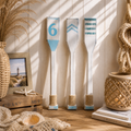 Drei dekorative paddel aus holz mit weißen und blauen akzenten maritime wandkunst mit nummer 6 doppelpfeilen und streifen