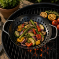 Schwarzer gemüsekorb rund 28 cm aus perforiertem metall mit griffen gefüllt mit gegrilltem gemüse wie spargel zucchini paprika und champignons