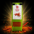 Grüne eco food tüte cayenne pfeffer mit durchsichtigem fenster zeigt leuchtend rotes gemahlenes gewürz