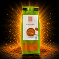 Eine grüne tasche kurkuma gemahlen 60 g mit weißem etikett und goldenem orangenem kurkuma puder auf einem bild