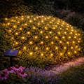 Solar led lichternetz 180x120cm mit warmgelben led-lichtern in diamantmuster an grünem hecken, solarbetrieben